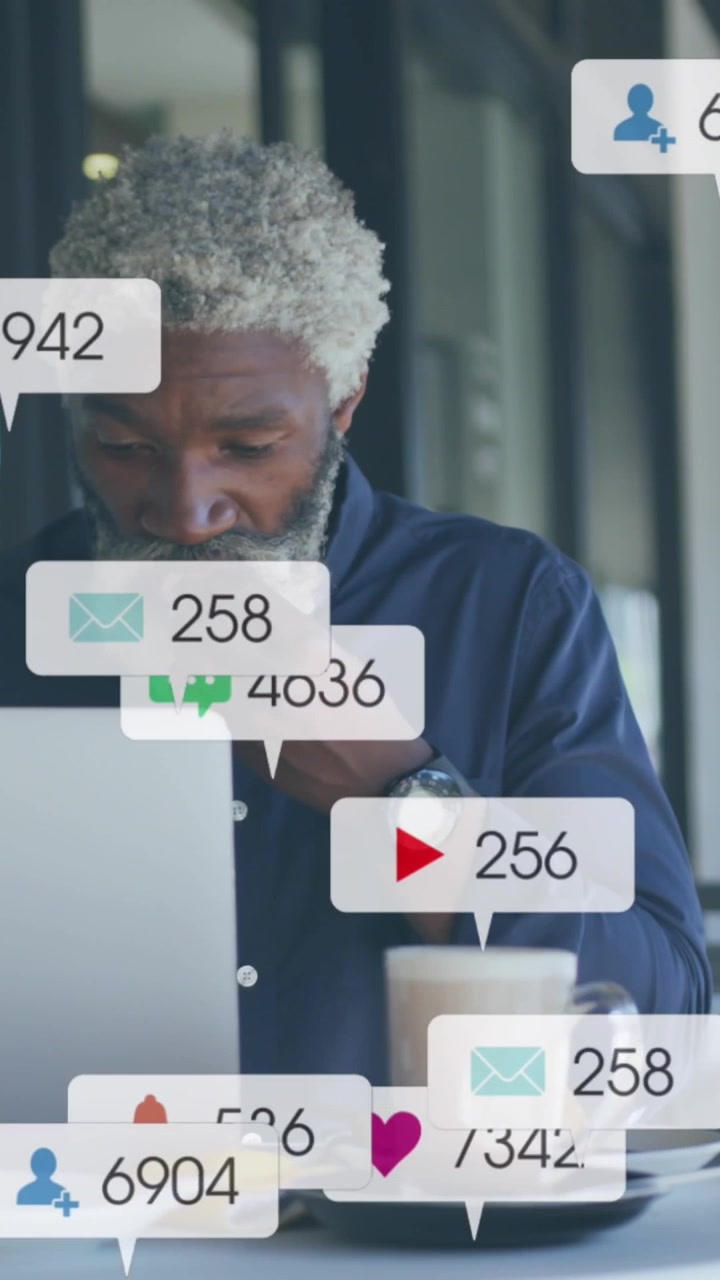 Animation of social media icons and numbers over african american businessman with laptop