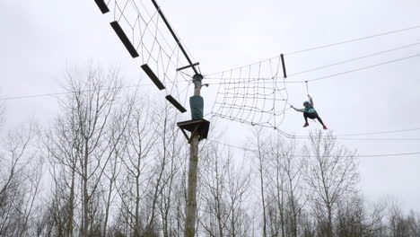 Young-girl-alone-on-a-high-zip-wire-in-the-woods