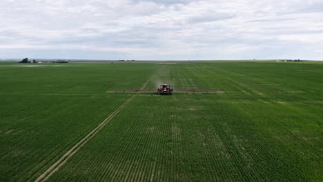 tractor spraying wheat field at daytime in saskatchewan, canada