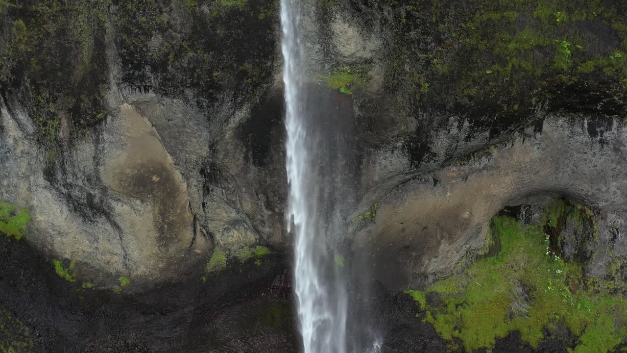 Aerial View of a Waterfall Cascading Down a Mountain Cliff
