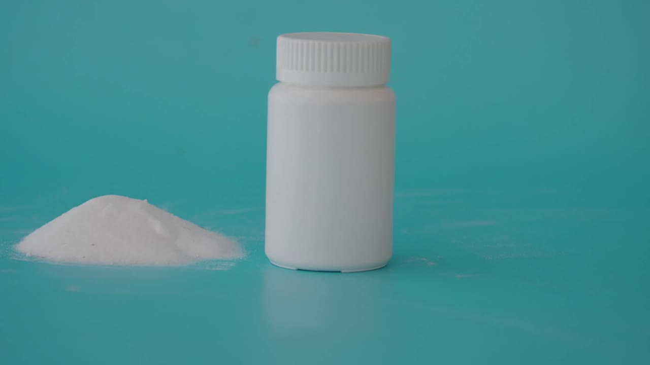 Polvo blanco y botella de medicina sobre un fondo azul