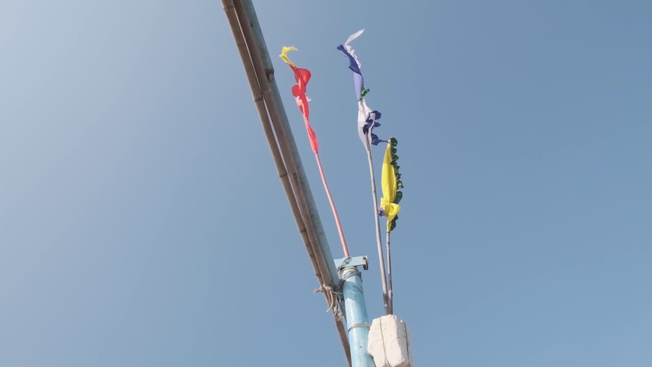 banderas en el mástil de un pequeño barco de pesca indio que sopla en el viento del mar a cámara lenta