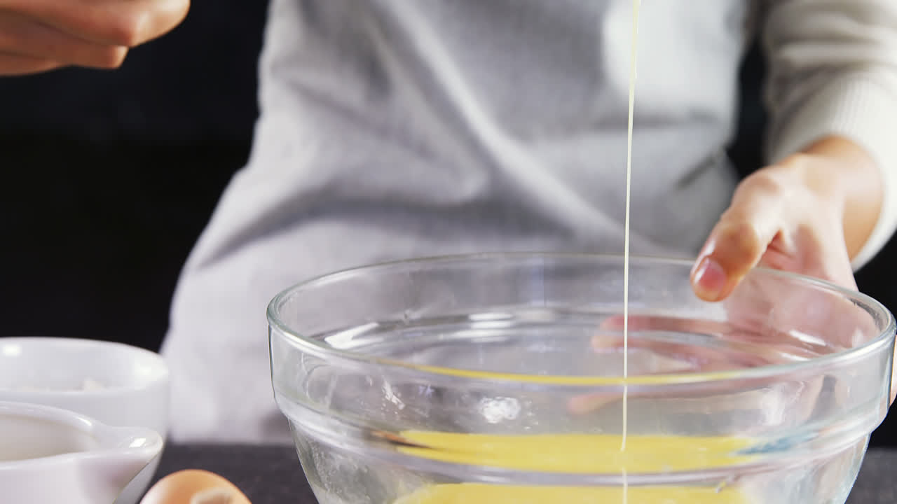 mujer golpeando huevo en cuenco 4k