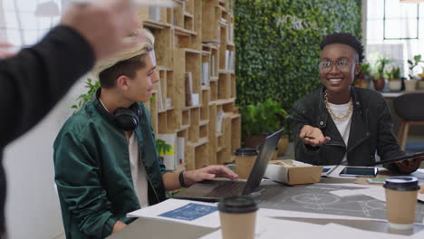 jóvenes ingenieros desarrollando prototipos de bicicletas utilizando esquemas de planos, haciendo lluvia de ideas sobre el desarrollo futuro, colaborando, compartiendo ideas creativas en una oficina de moda.