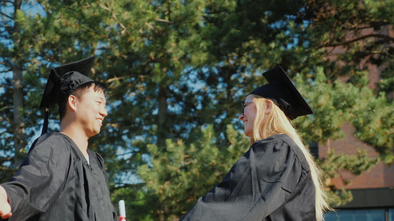 Graduates Congratulate Each Other On Graduating From College Hugging