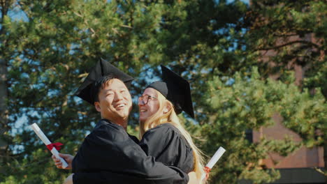 graduates congratulate each other on graduating from college hugging