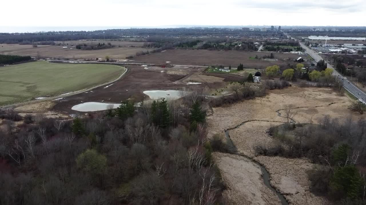 drone volando sobre las tierras de cultivo de ajax en invierno junto a una carretera