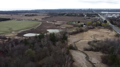 drone flying over ajax farmland in winter next to a highway
