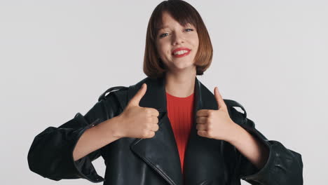 Smiling-girl-giving-thumbs-up-in-studio