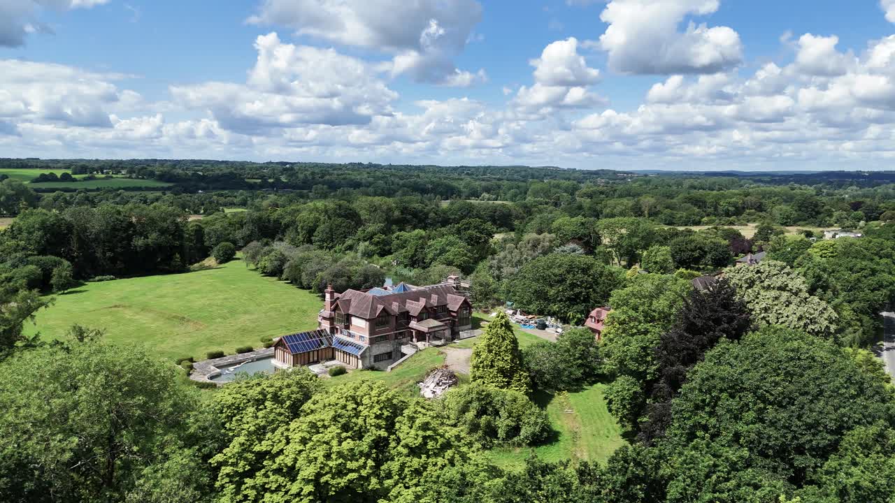 Secluded luxury celebrity real estate aerial view surrounded by lush overgrown uk woodland