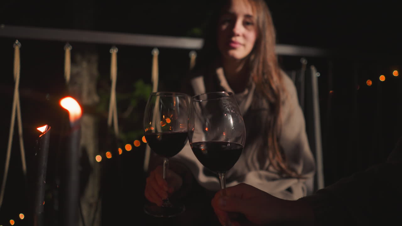 밤 에 마당 에서 와인 을 마시고 있는 부부