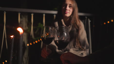 una pareja disfrutando del vino en un patio por la noche