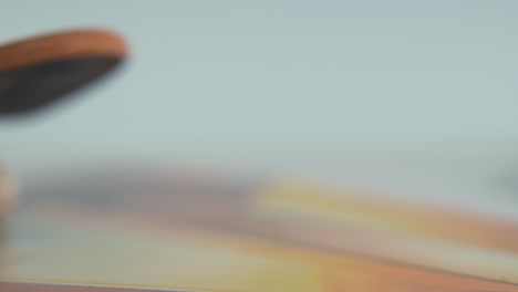 a hyper macro detailed shot of a mini skateboard, tiny white wheels, riding fingerboard from left to right, blurry depth of field to focus, professional lighting, static cinematic 4k video