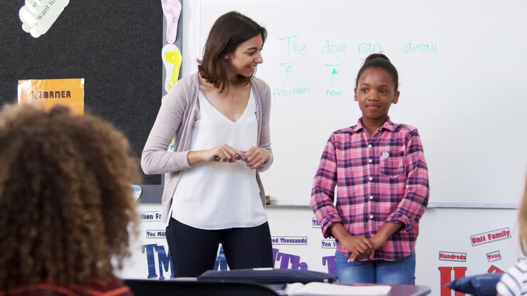Teacher and pupil presenting to elementary school class
