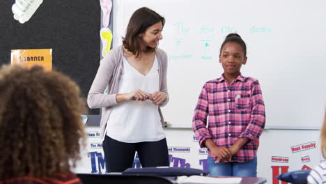 teacher and pupil presenting to elementary school class