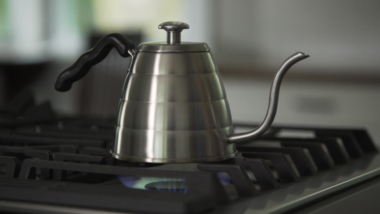 Metal Kettle Boiling Water on Fire Stove in Slow Motion