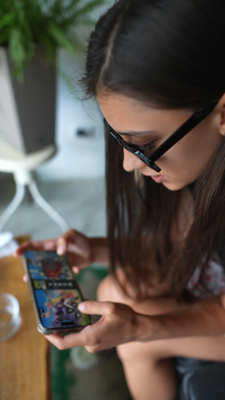 adolescente jugando a un juego móvil en un café