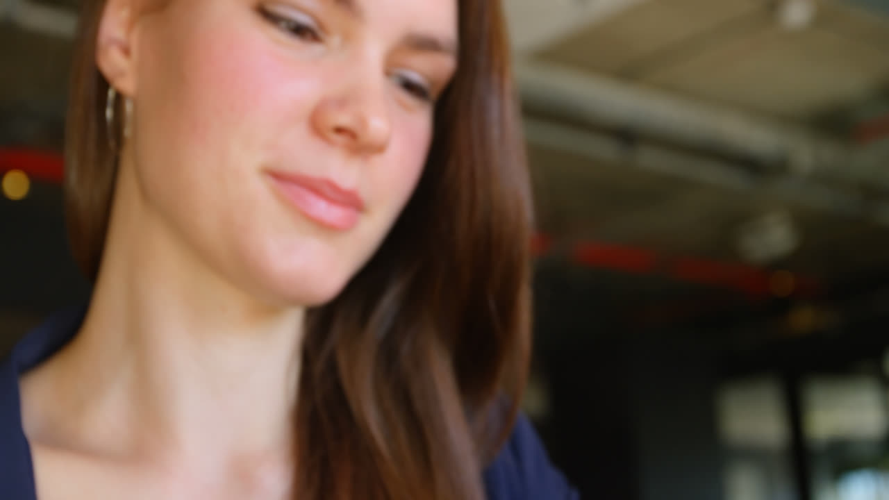 vista frontal de una joven mujer de negocios caucásica trabajando en una tableta digital en una oficina moderna 4k