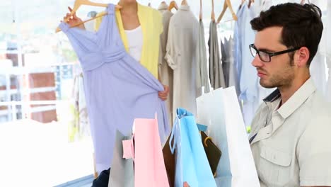 novio aburrido frunciendo el ceño ante la cámara mientras la novia compra