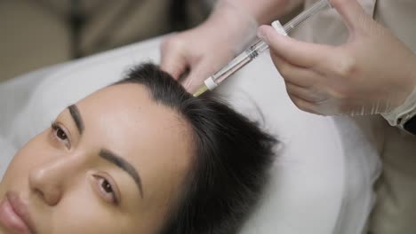 a focused treatment of mesotherapy on the scalp to enhance hair vitality, showcasing the precision and care of the medical practitioner