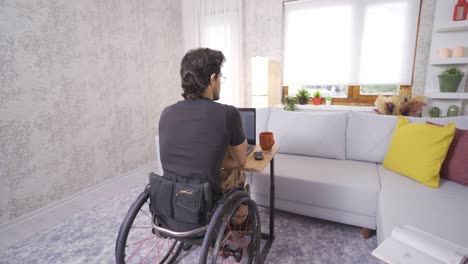 Disabled-young-man-sits-in-wheelchair-and-works-with-laptop.