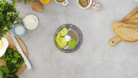 crop woman preparing cashew avocado dip in blender