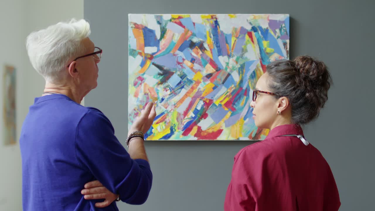 Gallery Worker and Curator Hanging Painting on Wall