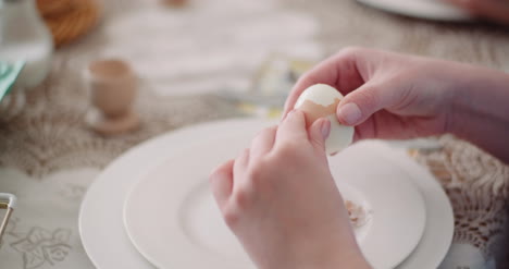 mujer pelando huevo en plato 3