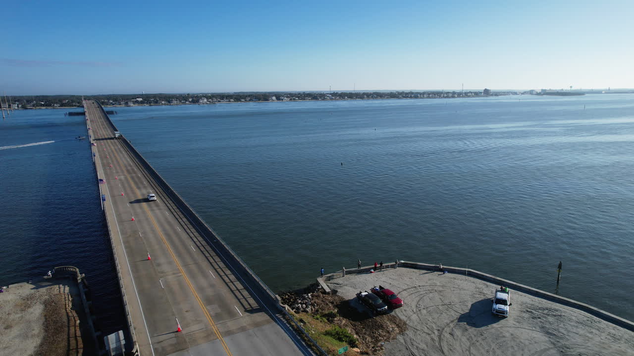 tomada de un dron del puente de la playa atlántica con la ciudad de morehead en la distancia con barcos