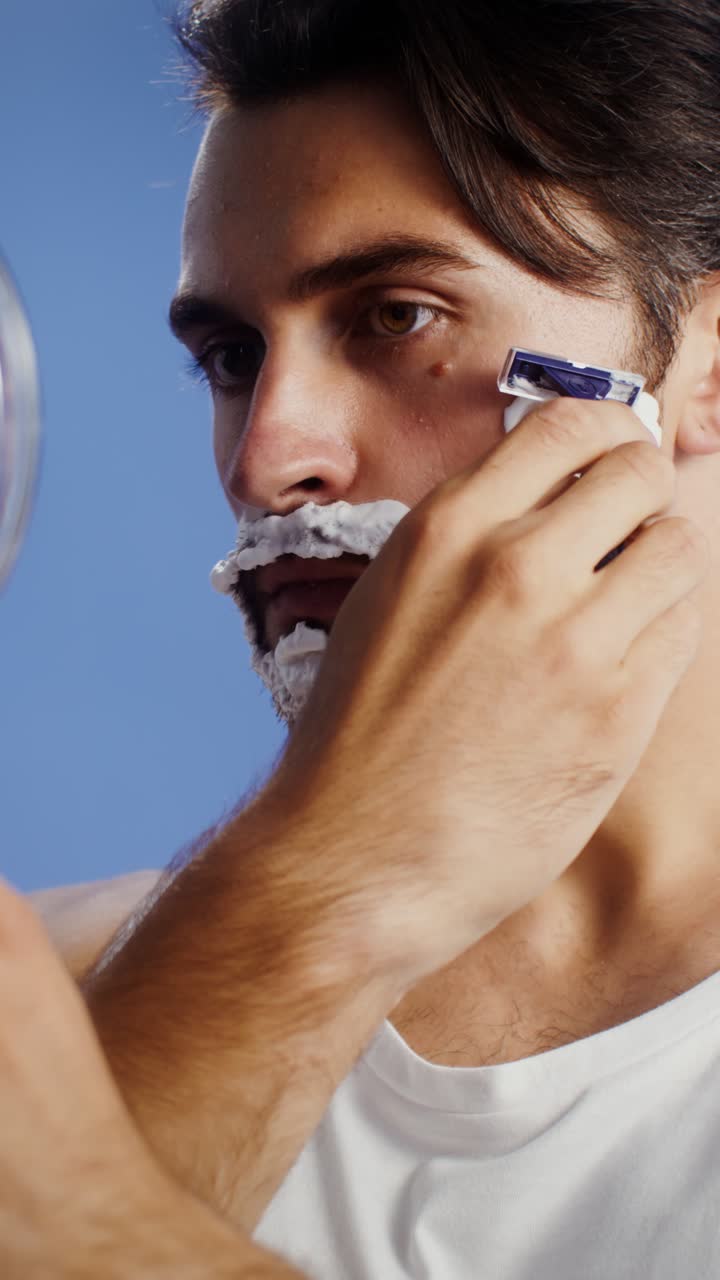 Man Shaving with Razor and Cream in Mirror