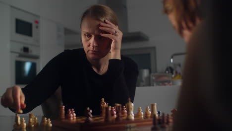 mother and her son compete in a game of chess