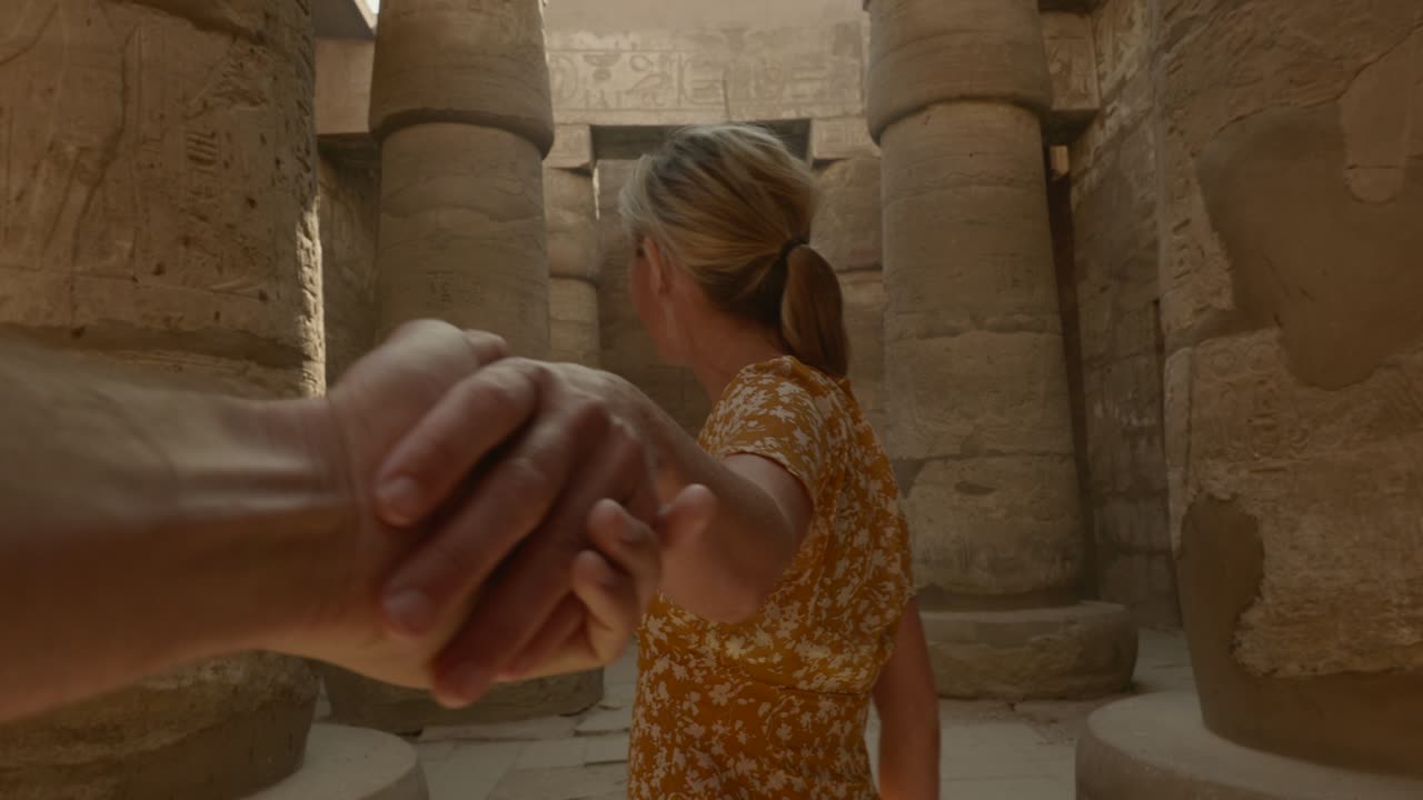 Følg meg til Egypt: Ungt par holder hender mens de ser på et eldgammelt egyptisk tempel