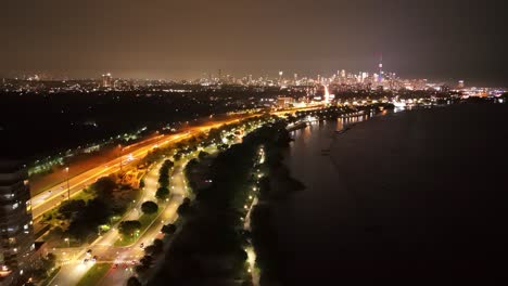 traffic lights and skyline glow at night over downtown waterfront of toronto, ontario, aerial dolly