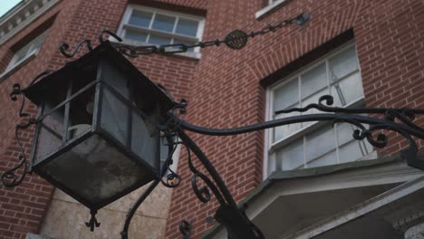 huge black metal lantern on an abandoned house with wrought windows