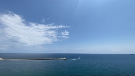 Malerische-Aussicht-Auf-Das-Meer-Mit-Hellem-Himmel-Und-Einem-Boot,-Das-In-Einen-Hafen-Einfährt