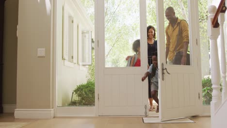 una familia de dos generaciones entrando en su casa.