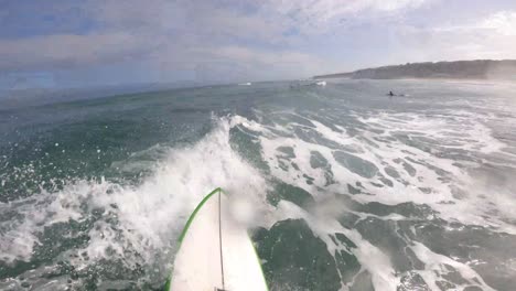 view of some strong rider generating some speed on a perfect wave with a good reentrie off the lip in praia da adraga, sintra, portugal