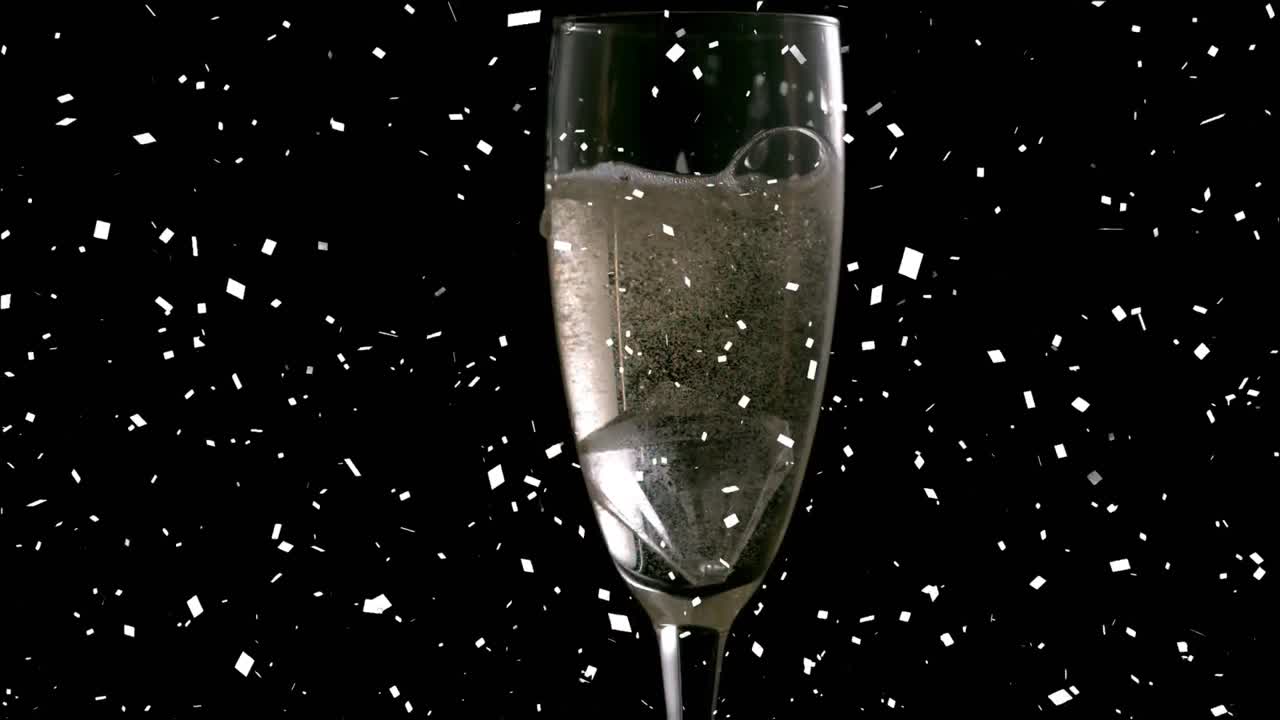 animación de confeti cayendo y champán vertiendo en un vaso de champán sobre un fondo negro