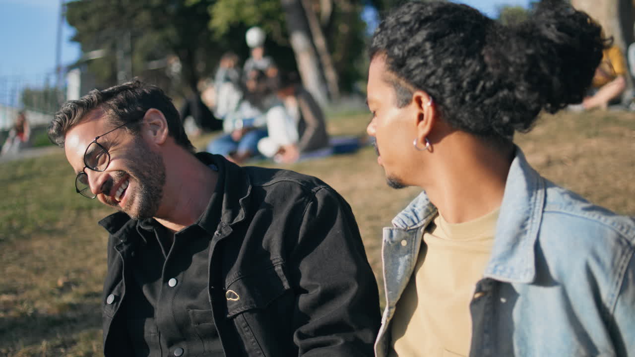 Dos hombres conversando en un parque.