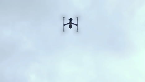 a dji inspire 2 professional quadcopter drone taking off, rising then flying out of frame