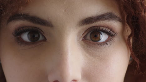 close up of young woman eyes looking at camera blinking surprise expression