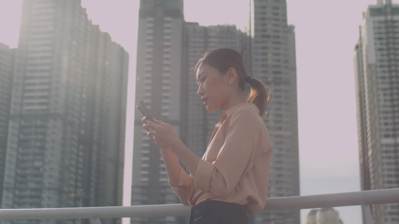 Asian Businesswoman Using Phone on Street