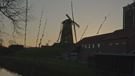 focusrack desde el histórico molino de viento en los países bajos hasta las cañas cerca del río al atardecer - ancho