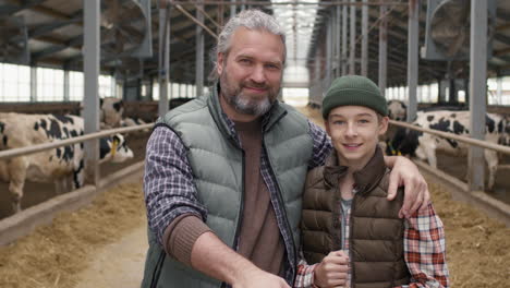 father and son posing at dairy farm