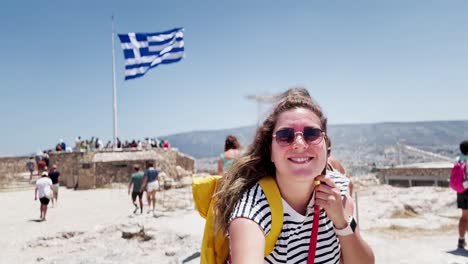 happy tourist posing with the greek flag in athens, greece