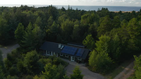 Hochwinkelansicht-Von-Häusern-Oder-Cottages-Unter-Bäumen.-Kippen-Sie-Nach-Oben,-Um-Die-Meeresküste-Und-Die-Wasseroberfläche-Freizulegen.-Dänemark