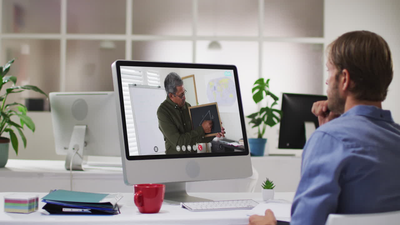 Caucasian male student using computer on video call with male teacher