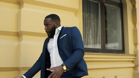 afro business man dancing outdoors. winner businessman clapping hands at street.