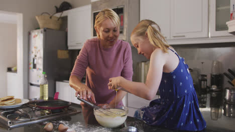 Vista-Lateral-De-Una-Mujer-Caucásica-Cocinando-Con-Su-Hija-En-Casa