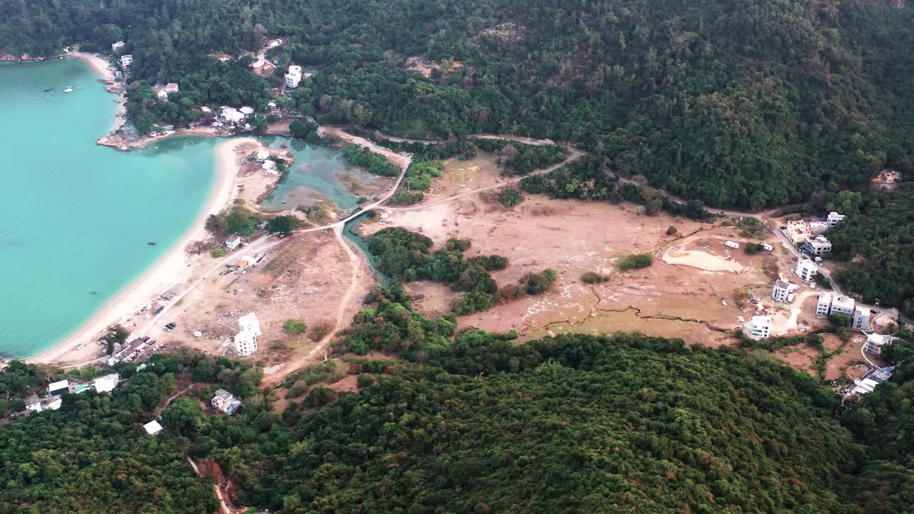 camión aéreo a la izquierda de agua turquesa en la bahía de pui o beach rodeada de colinas de selva tropical durante el día en la isla de lantau, hong kong, china